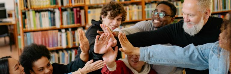 a teacher and a group of children high fiving